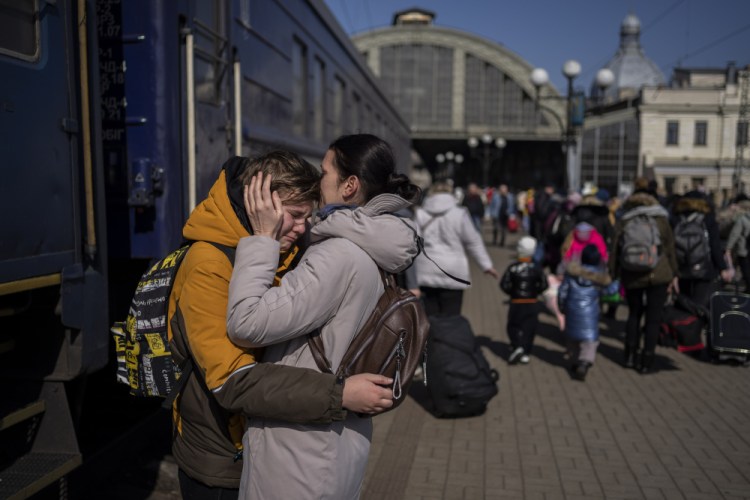 A mother embraces her son who escaped the besieged city of Mariupol and arrived at the train station in Lviv, western Ukraine on Sunday.