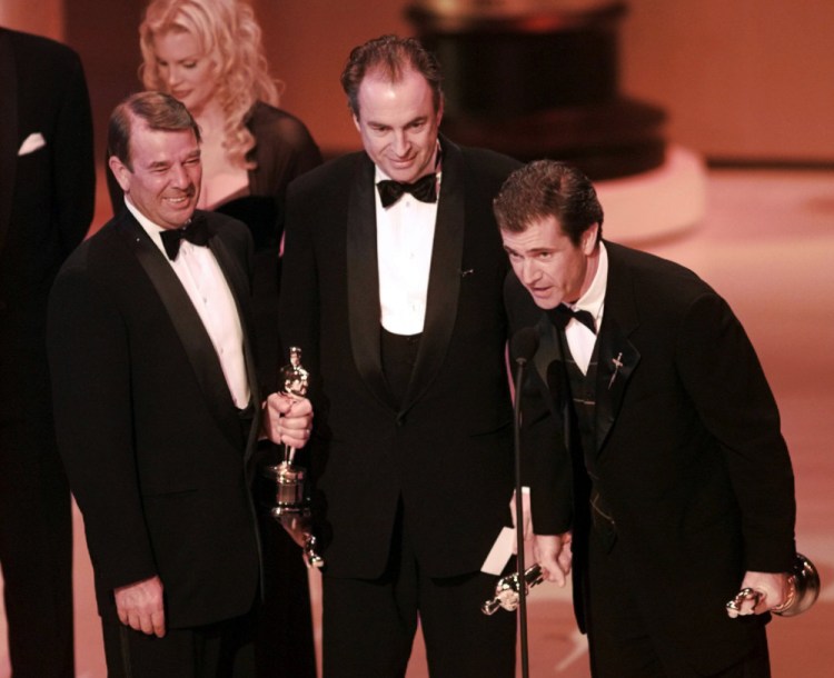 Mel Gibson, right, accepts the award for Best Picture for "Braveheart" at the Academy Awards in 1996. With Gibson are co-producers Alan Ladd Jr., left, and Bruce Davey.