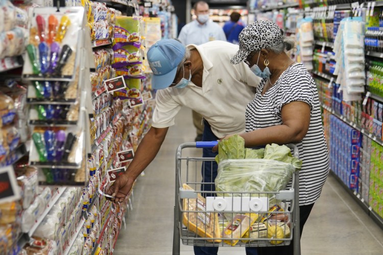 Ray Carter, left, and Bobbie Carter shop at the Homeland grocery store in September in Oklahoma City.  Consumers facing higher prices for products made with corn and wheat could be in for more pain as global supplies tighten because of Russia’s invasion of Ukraine. 