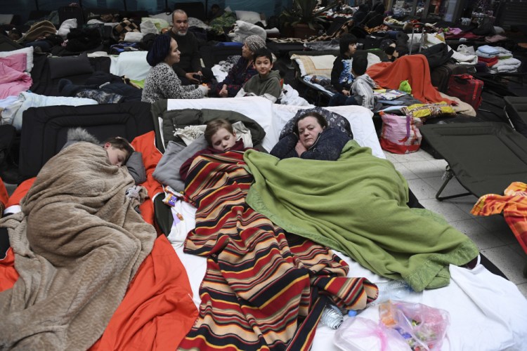 People sleep on cots at a reception center in Korczowa, Poland, on Saturday.

