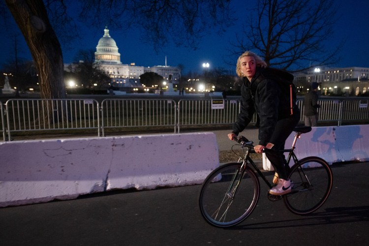 Liz Sluchak, an employee with Dreamy – a self described motivational speech company – rides her bike to make a "delivery" in Washington, D.C. on March 04, 2022.