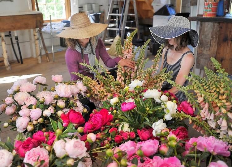 Stacy Brenner, left, who owns Broadturn Farm with her husband, John Bliss, sorts flowers with an employee in this archive photo. 