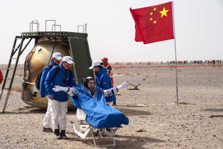Astronaut Ye Guangfu sits outside the capsule of the Shenzhou 13 manned space mission after landing at the Dongfeng site in the northern region of Inner Mongolia on Saturday.