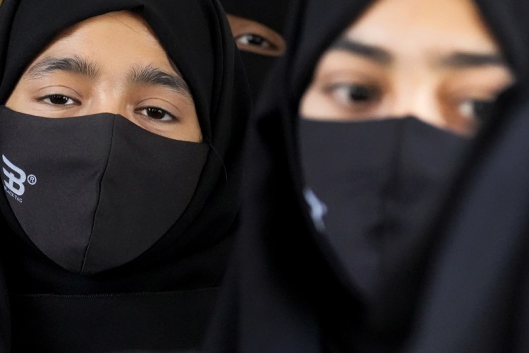 Muslim students wearing hijabs and face masks gather to meet activists in Kundapur, India, on Feb. 26.