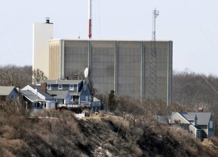 Part of the Pilgrim Nuclear Power Station is visible beyond houses along the coast of Cape Cod Bay, in Plymouth, Mass. 