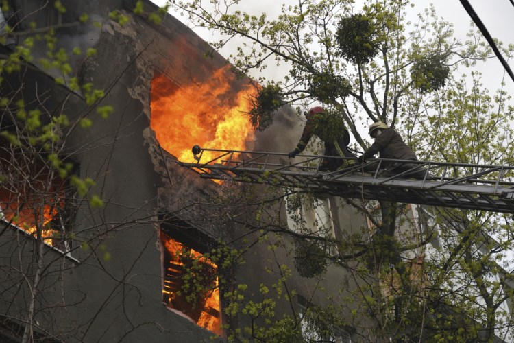 Firefighters work to extinguish fire at an apartments building after a Russian attack Sunday in Kharkiv, Ukraine.
