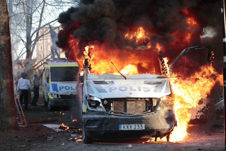 Protesters set fire to a police bus in the park Sveaparken in Orebro, Sweden, on Friday.