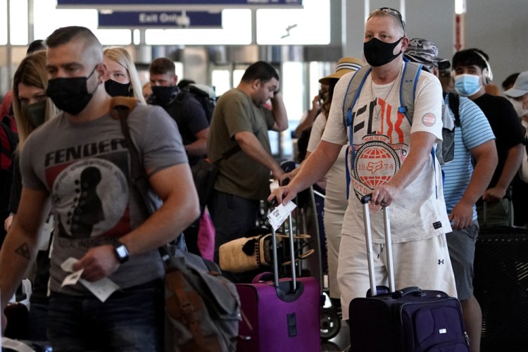 Travelers line up at Chicago's O'Hare International Airport on April 12. A federal judge in Florida has voided the national mask mandate that applies to public transit.