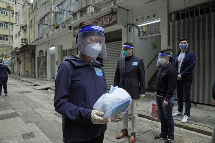 Hong Kong Chief Executive Carrie Lam holds a package of coronavirus prevention materials to be delivered to residents Saturday.