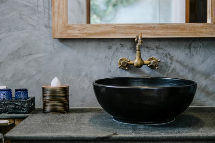 Singular black highlights, like the sink bowl or slate countertops, can make a strong impression in the bathroom.