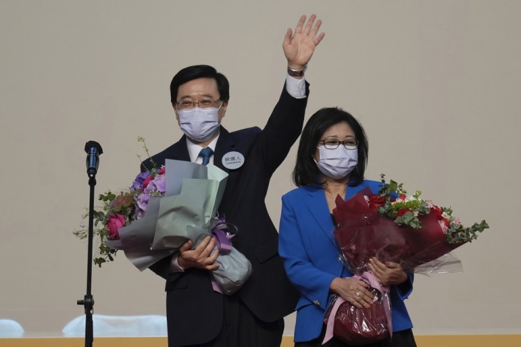 John Lee, former No. 2 official in Hong Kong and the only candidate for the city's top job, celebrates with his wife after declaring his victory Sunday in Hong Kong. Kin Cheung/Associated Press