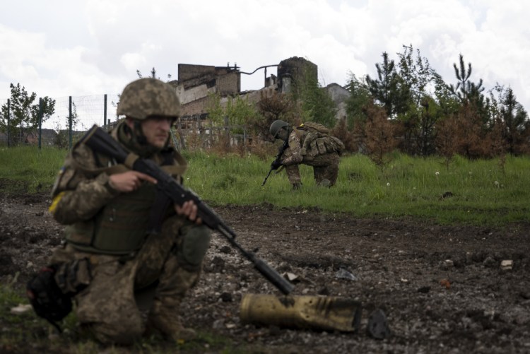Ukrainian servicemen squat during a patrol in a recently retaken village, north of Kharkiv, east Ukraine, on Sunday.