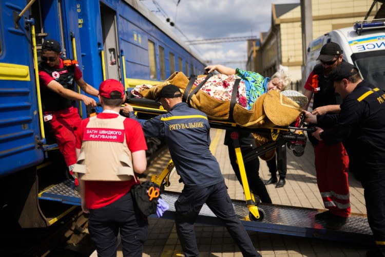 A patient is carried on a stretcher to board a medical evacuation train run by Doctors Without Borders at the station in Pokrovsk, eastern Ukraine, on Sunday. The train is specially equipped and staffed with medical personnel, and ferries patients from overwhelmed hospitals near the front line to medical facilities in western Ukraine, far from the fighting.
