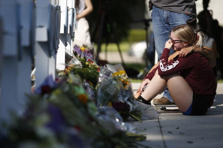 A woman reacts as she pays her respects Thursday at a memorial site for the victims killed in this week's elementary school shooting in Uvalde, Texas.