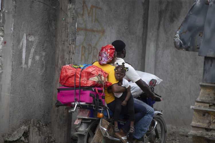Residents travel on a motorbike as they flee their home to avoid clashes between armed gangs, in the Croix-des-Mission neighborhood of Port-au-Prince, Haiti, on April 28.