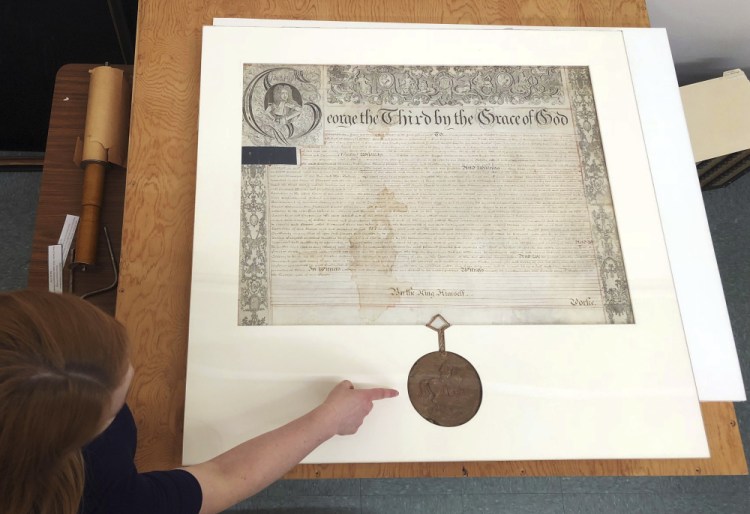 Rhode Island state archivist Ashley Selima points to the seal of King George III on a September 1772 proclamation. The document established a commission to investigate the burning of the British schooner HMS Gaspee by colonists in Narraganset Bay in June 1772.