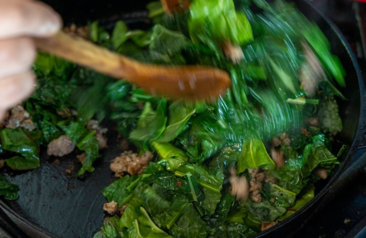 Sautéing local sausage with kale, Swiss chard and onions. The mixture comes in handy for many dishes, including grilled pizza. 