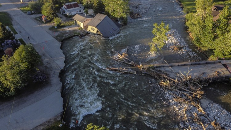 A house sits in Rock Creek after floodwaters washed away a road and a bridge in Red Lodge, Mont. on Wednesday.