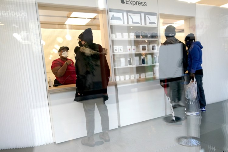 Customers pick up online orders at the Apple Store at the Towson Town Center in Towson, Md., in 2020. Apple store employees in the Baltimore suburb voted to unionize by a nearly 2-to-1 margin on Saturday.