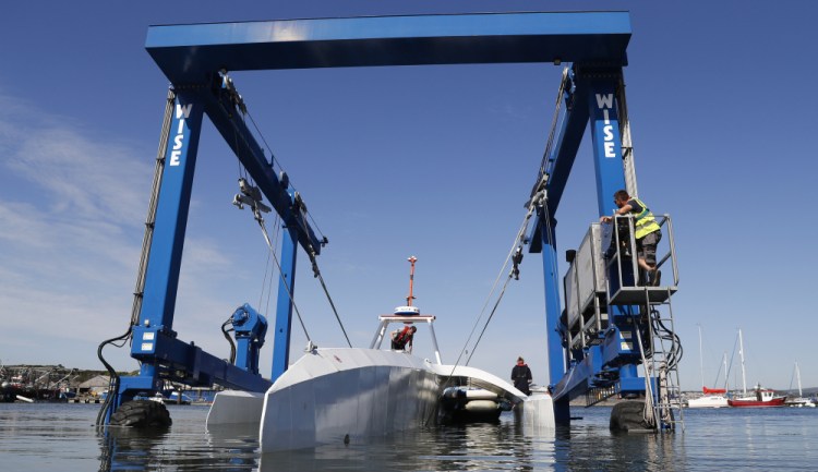 Technicians lower the Mayflower Autonomous Ship into the water at its launch site on Sept. 14, 2020, for its first outing on water since being built in Turnchapel, Plymouth, in southwest England. The sleek autonomous trimaran docked in Halifax, Nova Scotia on Sunday after more than five weeks crossing the Atlantic Ocean from England, according to tech company IBM, which helped build it. (AP Photo/Alastair Grant, File)