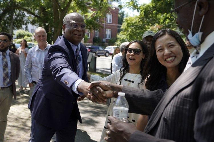 Michael Cox, who has been named as the next Boston police commissioner, shakes hands as Boston Mayor Michelle Wu, right, looks on during news conference Wednesday.