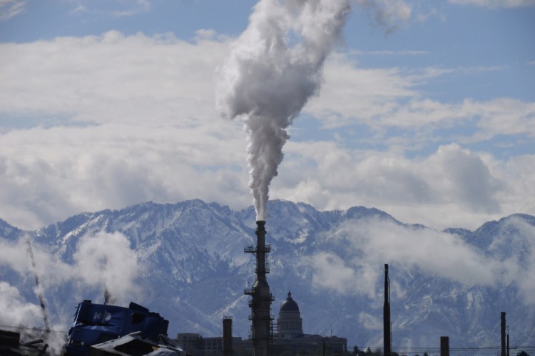 The Utah State Capitol, rear, is shown behind an oil refinery  in Salt Lake City. President Biden is promising “strong executive action” to combat climate change, despite dual setbacks.