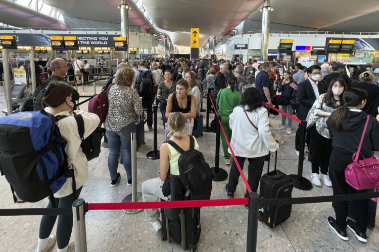 Travelers queue at security at Heathrow Airport in June 22. Airlines are expected to operate flights over the summer with an overall daily capacity of 104,000 seats, or 4,000 more than Heathrow can handle, the airport said.