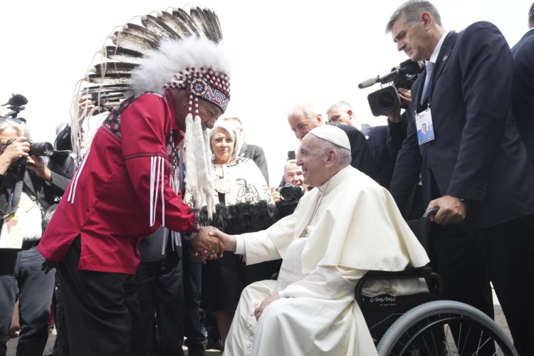 Pope Francis is greeted by George Arcand, Grand Chief of the Confederacy of Treaty Six First Nations, as he arrives in Edmonton, Alberta, Canada, on Sunday. His visit to Canada is aimed at reconciliation with Indigenous people for the Catholic Church's role in residential schools.