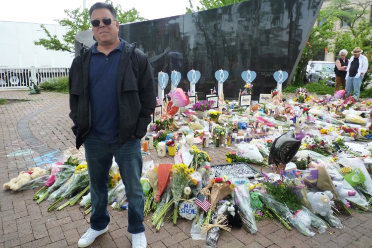 Bobby Shapiro of Highland Park, Ill., stands at a memorial for victims of the July 4 Highland Park mass shooting. “It was pure horror. It was a battle zone,” Shapiro, 52, said in an interview.