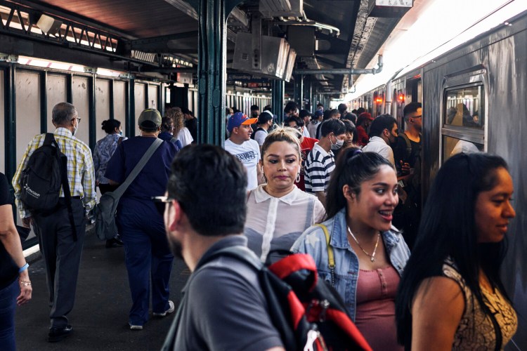 Commuters board the subway in New York, which still requires masks on trains and indoor stations. MUST CREDIT: Photo for The Washington Post by An Rong Xu