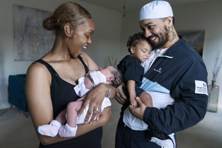 Aaliyah Wright, 25, of Washington, holds her newborn daughter Kali, as her husband Kainan Wright, 24, of Washington, holds their son Khaza, 1, in Accokeek, Md., on Aug. 9. Kali is eligible for the Baby Bonds program, but at a lower level because of the family's income. "At that stage of maturity and adulthood, that money can be a door opener to some pretty big things,” Kainan Wright said.