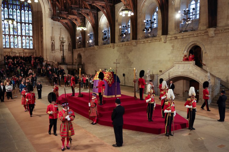 The King's Body Guard, formed of Gentlemen at Arms, Yeomen of the Guard and Scots Guards, change guard duties around the coffin of Queen Elizabeth II  inside Westminster Hall, on Sunday.