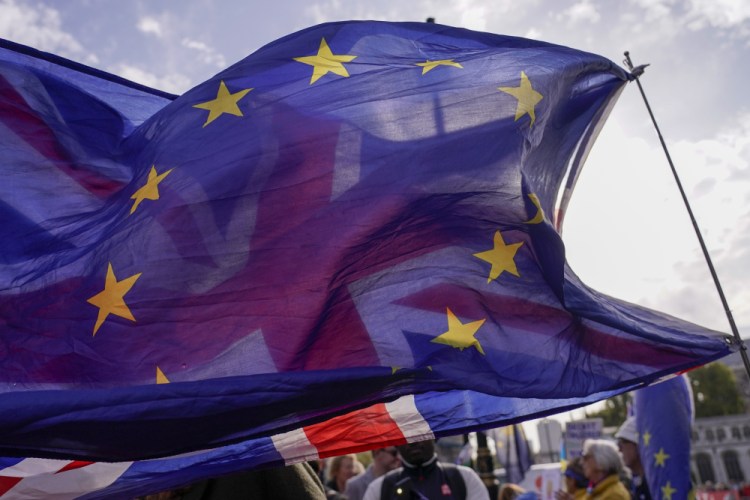 A Union flag waves behind a European Union flag, outside the Houses of Parliament, in London on Wednesday. 