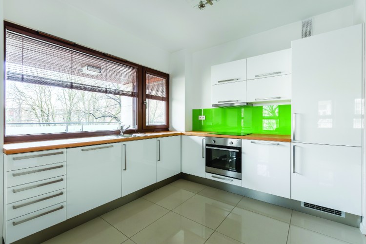 Modern, white kitchen with green backsplash and long window