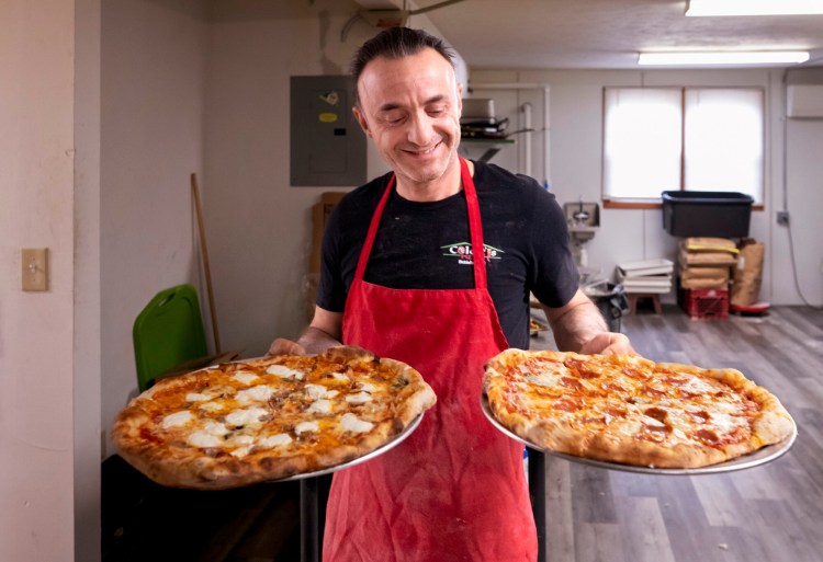 Francesco "Frank" Coletti carries pizzas out to customers at Coletti's Pizza Factory in Biddeford. The pizza was recently named by Yelp among the best 100 pizzas in the U.S. and Canada. 