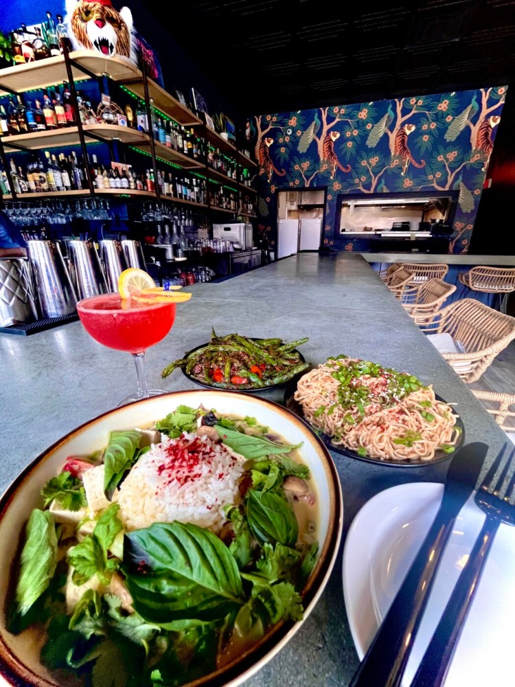 Vegan dishes at the upscale cocktail lounge Paper Tiger include the tom kha gai rice, the Szechuan green beans (without feta), and the Szechuan cold noodles served with a vodka cocktail called Hot Girl Lab Coat.