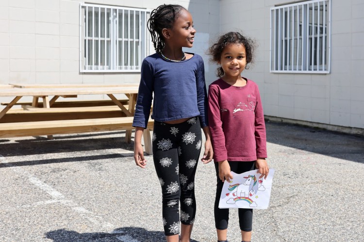 Sisters Emilia, 6, left, and Fatima Toubaji, 5, who are recent arrivals from Angola, stand outside Portland Public Schools district office after Emilia enrolled in kindergarten. Fatima will have to wait until next school year to attend kindergarten. 