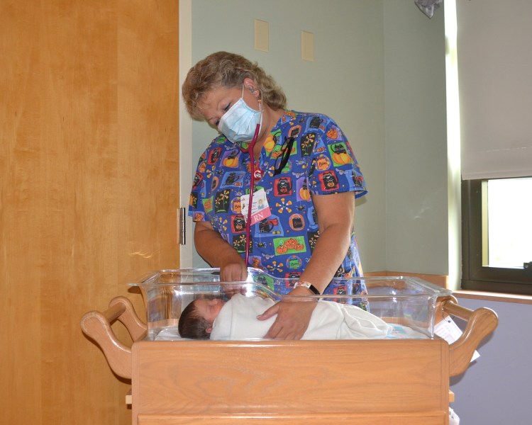 A registered nurse with Franklin Memorial Hospital in Farmington assesses a newborn baby. 