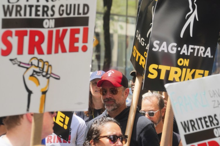Actor Jason Sudeikis, center, walk a picket line with striking writers and actors on Friday at NBC Universal Studios in New York. Bebeto Matthews/Associated Press