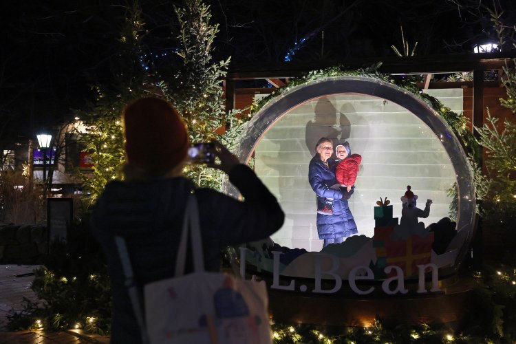  Pam Davis and Rosa Davey pose within a giant snow globe at L.L. Bean in Freeport as Gillian Davis takes a photo of her mother and daughter. 